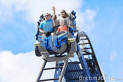 Young family having fun riding a rollercoaster at a theme park Stock Photo