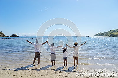 Young family lifting hands together on the beach Stock Photo