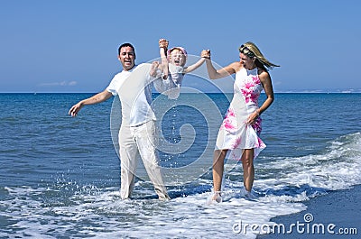 Young family playing with daughter on beach in Spain Stock Photo