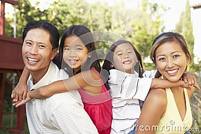 Young Family Playing In Garden Together Stock Photo