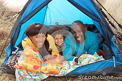 Young Family Relaxing Inside Tent On Holiday Stock Photo