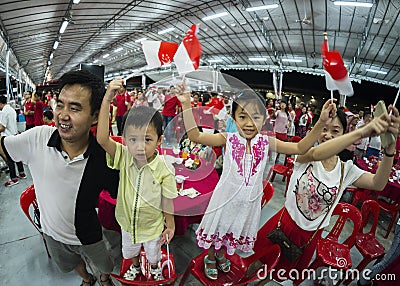 A young family sing one of the national day song and wave mini national flags with pride and joy Editorial Stock Photo