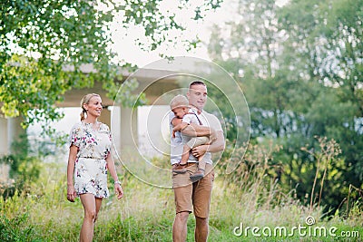 Young family with a small crying toddler boy in sunny summer nature. Stock Photo