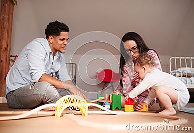 Young family with small toddler son indoors at home, playing. Stock Photo