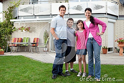 Young family standing in front of their house Stock Photo