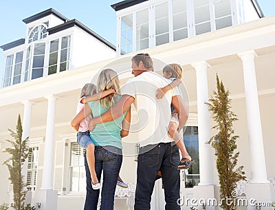 Young Family Standing Outside Dream Home Stock Photo