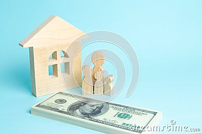 A young family stands near a wooden house and with a bundle of money. The concept of a strong family, the continuation of the fami Stock Photo