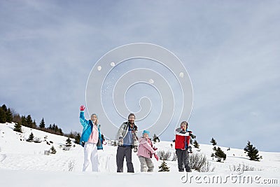 Young Family Throwing Snowballs Stock Photo