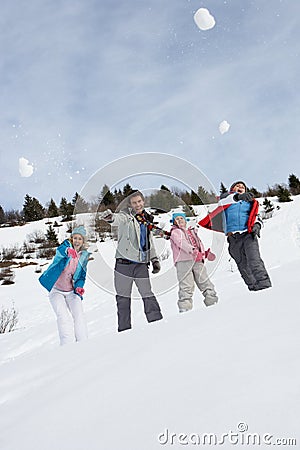 Young Family Throwing Snowballs On Winter Vacation Stock Photo