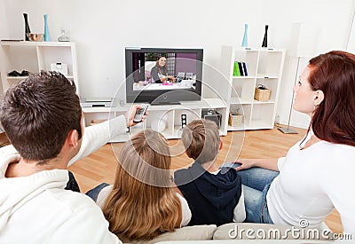 Young family watching TV at home Stock Photo