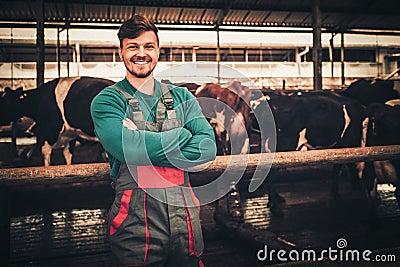 Young farmer in a cowshed on a dairy farm Stock Photo