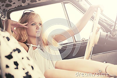 Young fashion blond woman relaxing in vintage car Stock Photo