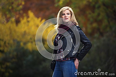 Young fashion blonde woman in black leather jacket and snood scarf Stock Photo