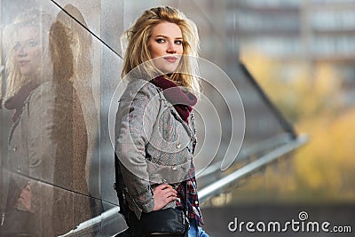 Young fashion blonde woman in checked plaid blazer and snood scarf Stock Photo