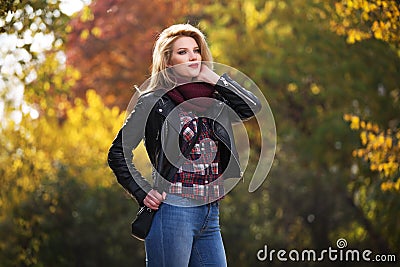 Young fashion blonde woman in black leather jacket and snood scarf Stock Photo