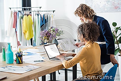 young fashion designers using laptop with google website on screen Editorial Stock Photo