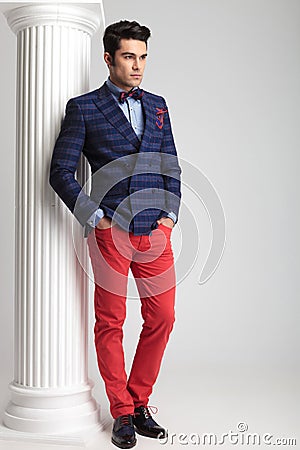 Young fashion man leaning on a white column Stock Photo