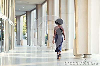 A young fashionable Afro-American woman walking away from the camera Stock Photo