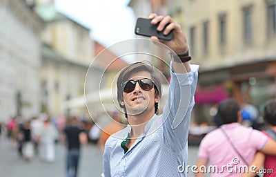 Young fashionable hipster Hispanic man with sunglasses taking a selfie Stock Photo