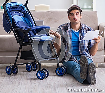 Young father assembling baby pram at home Stock Photo