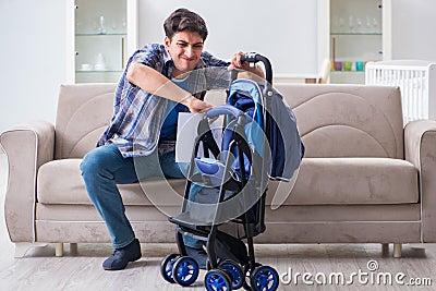 The young father assembling baby pram at home Stock Photo