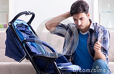 Young father assembling baby pram at home Stock Photo