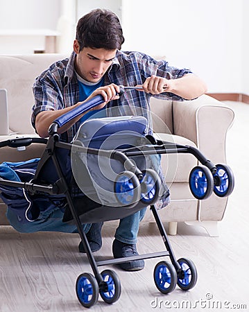 Young father assembling baby pram at home Stock Photo