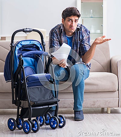 Young father assembling baby pram at home Stock Photo