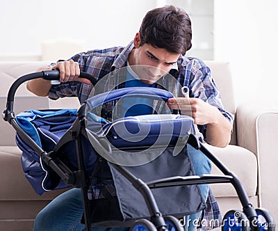 Young father assembling baby pram at home Stock Photo