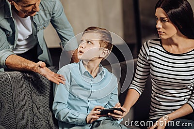 Young father scolding his son for binge-playing Stock Photo