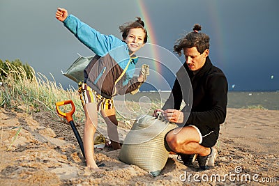 Young father with son on beach digging pit under the rainbow, playing, looking for treasure, lifestyle happy family on Stock Photo