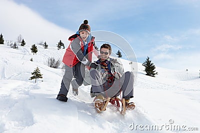 Young Father And Son Sledding Stock Photo