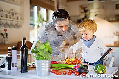 Young father with a toddler boy cooking. Stock Photo