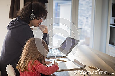Father working from home with little daughter during covid-19 lockdown. Side view, profile Stock Photo