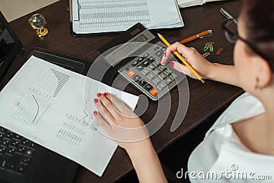 Young female accountant considers on calculator Stock Photo
