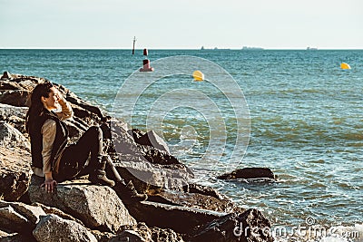 Young female adult standing in the sun next to the sea Editorial Stock Photo
