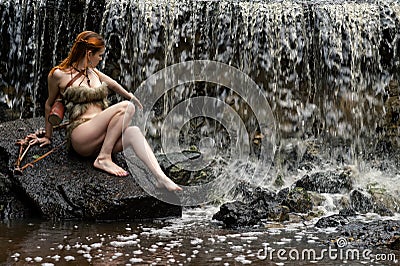 Young female archer enjoys waterfall Stock Photo