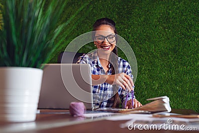 Young female architect working in her office, making some adjustments to her blueprint Stock Photo