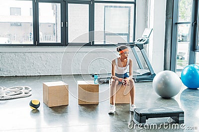 young female athlete sitting on wooden box Stock Photo
