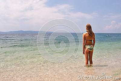 Young female in bikini facing the sea, wide view Stock Photo