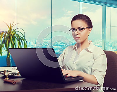 Female bookkeeper in glasses using laptop Stock Photo