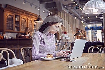 Woman works remotely online from cafe while quarantine coronavirus is in effect. Concept of checking mail, blogger, freelancer Stock Photo