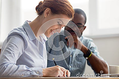 Young female candidate signing contract after successful interview in office Stock Photo
