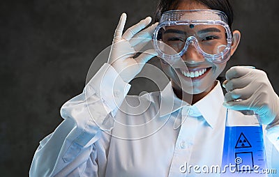Young female chemist doing science experiment with chemicals Stock Photo