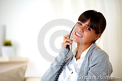 Young female conversing on phone looking at you Stock Photo