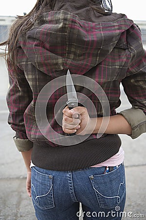 Young Female Criminal Holding Knife Stock Photo