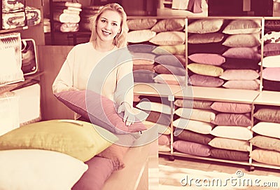 Young female customer is choosing new pillow Stock Photo