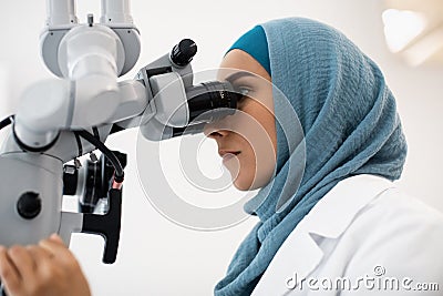 Female Dentist Doctor In Hijab Working With Modern Dental Microscope In Clinic Stock Photo