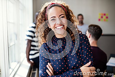Smiling female designer standing in an modern office Stock Photo