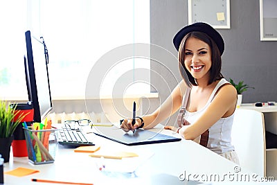 Young female designer using graphics tablet while working Stock Photo